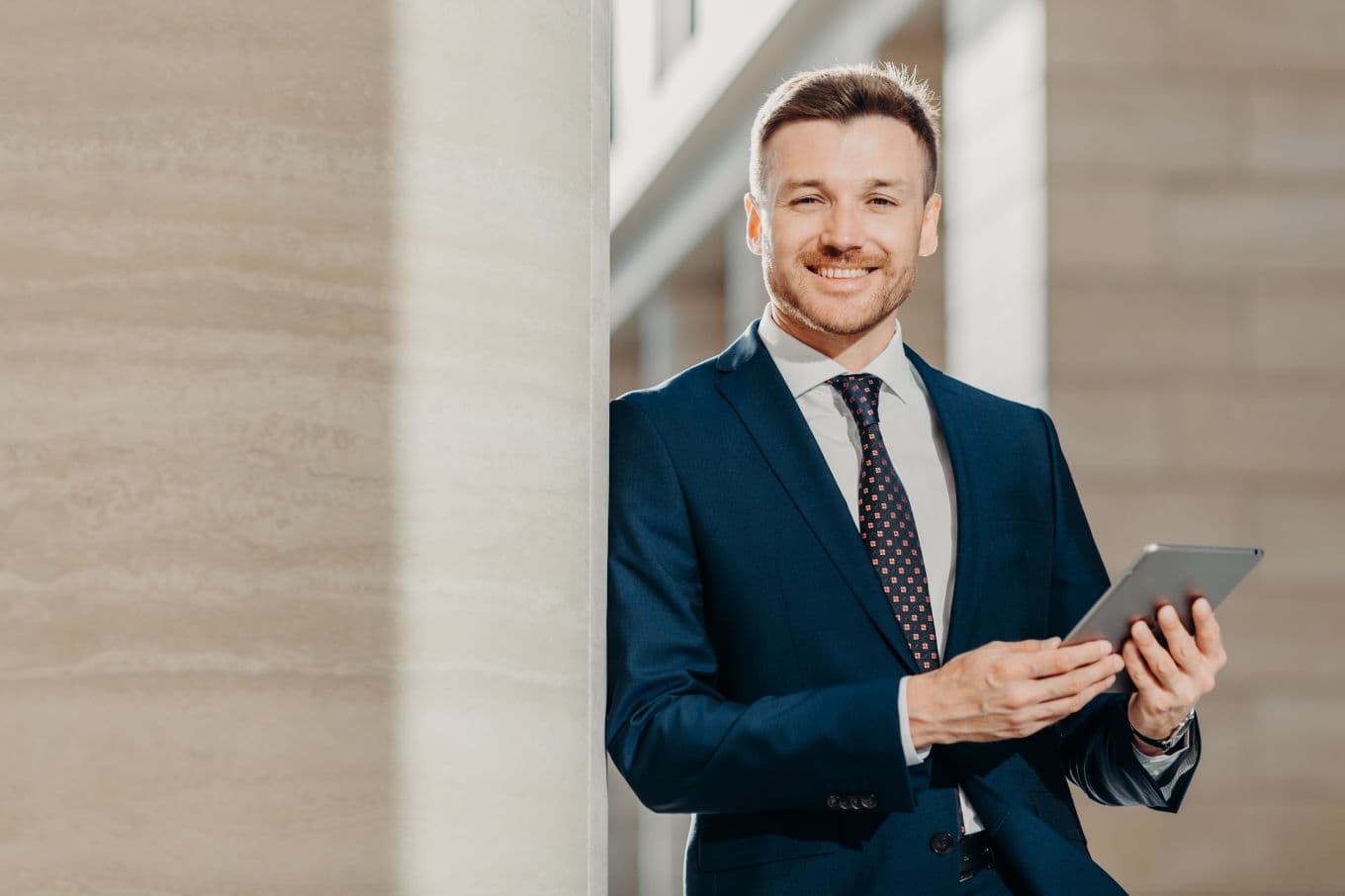 Smiling businessman holding a tablet